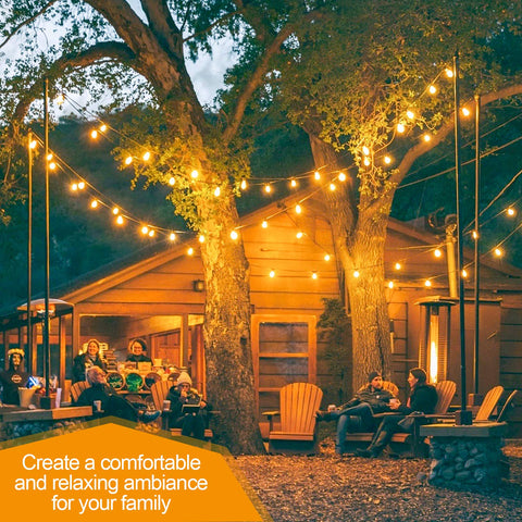 People sitting outdoors under string lights near a wooden cabin.