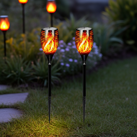 Solar garden lights with flame design on grass