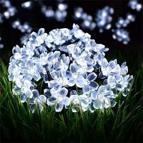 Solar garden fairy lights by Solightify, waterproof outdoor string lights with white flower-shaped design for garden decor.