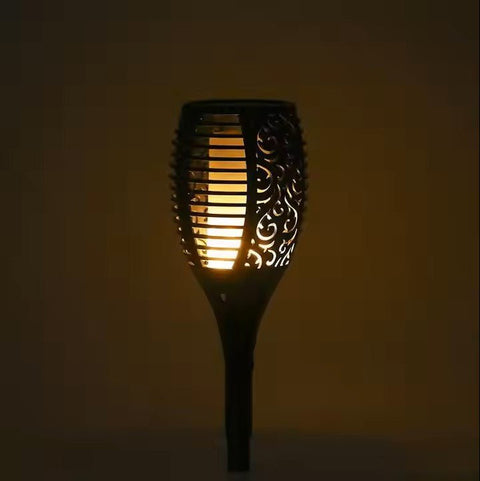 Solightify waterproof solar garden torch lights with flickering flame effect illuminating an outdoor garden pathway.